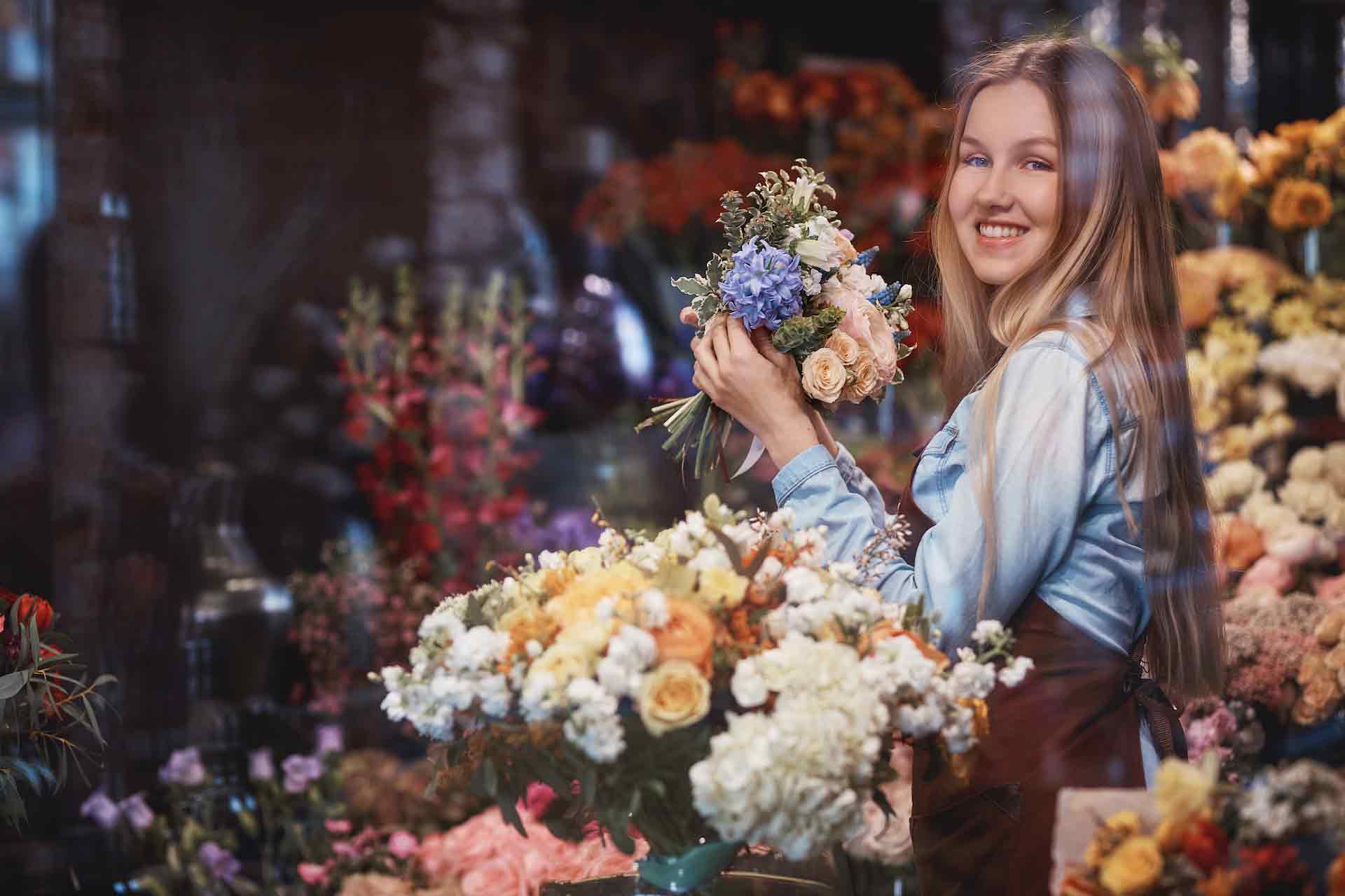 smiling young florist with flowers RG4EKXJ 1